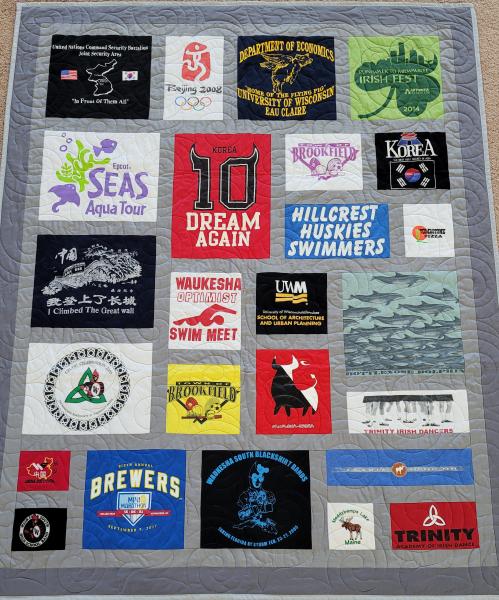 Mosaic T-shirt Quilt with Fabric in Between the T-shirt squares.
