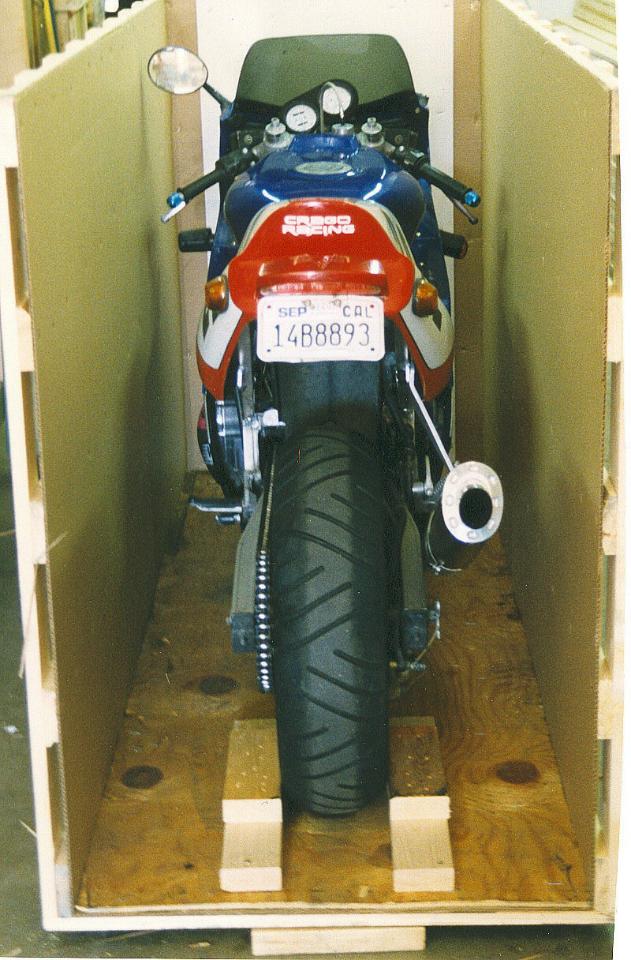 A motorcycle in a box, ready for shipping, placed in a room.
