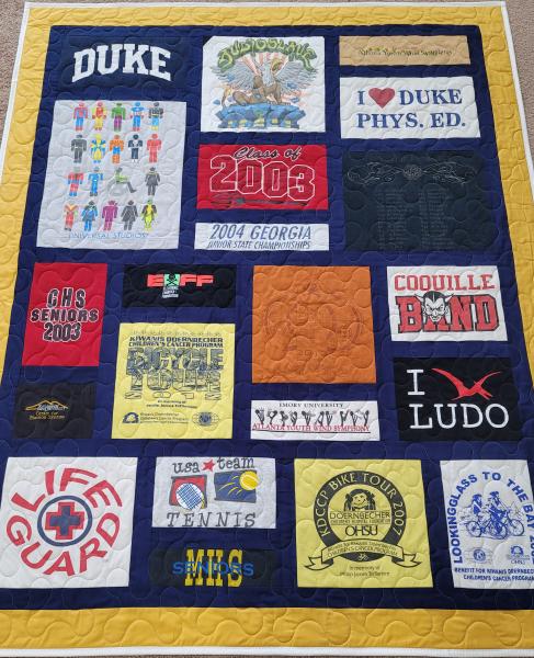 Mosaic T-shirt Quilt with Fabric in Between the T-shirt squares.